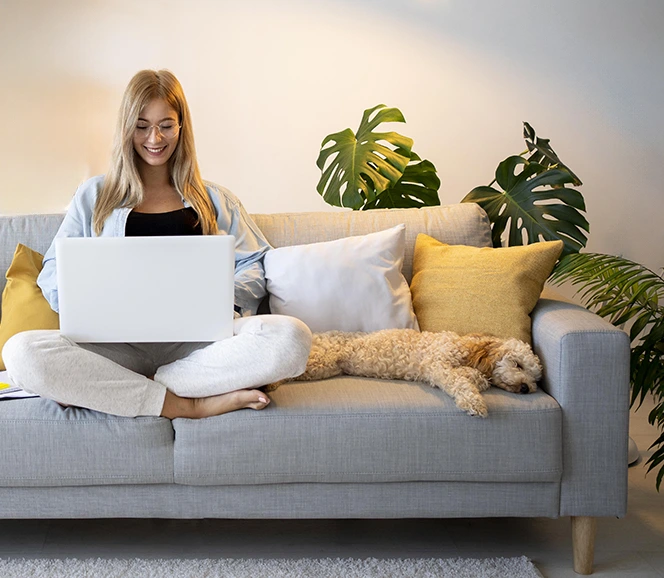 woman sitting on the couch with her dog during an online therapy session in San Diego California